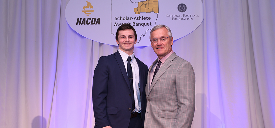 Senior Academic All-Ohio Athletic Conference defensive back Kyle Kelly being recognized for his award by Jim Tressel