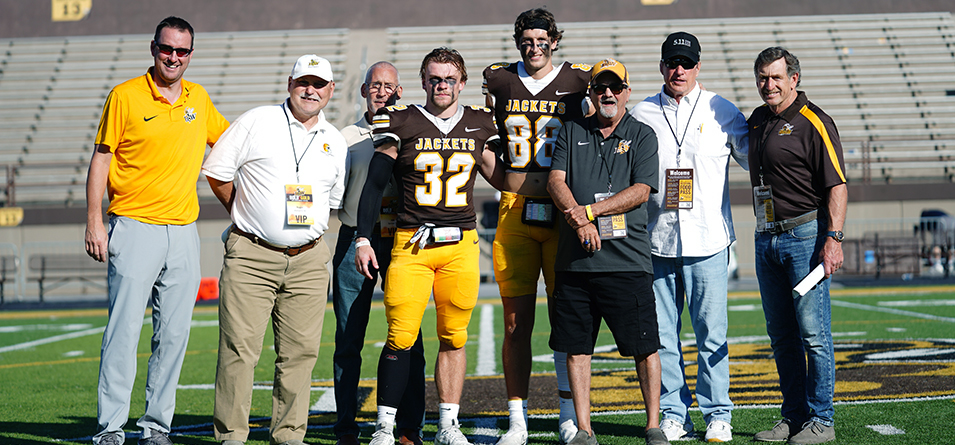 Frank Ropollo Offensive Player of the Game Austin Schuck and Dick Miller Defensive Player of the Game Mason Levasseur with Director of Athletics Steve Thompson and members of the 1978 Championship Team (Photo Courtesy of Lincoln Earl '24)