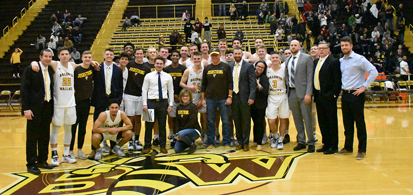 Josh Herron's family and BW men's basketball take a picture after the 81-71 victory over Hiram College
