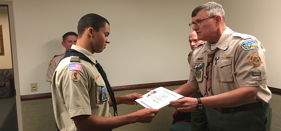 Junior All-OAC swimmer Greg Shaw receives his Eagle Scout certificate.